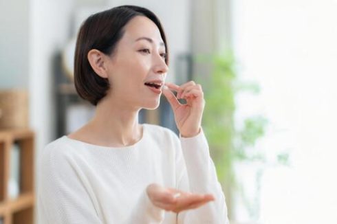 サプリを飲む女性